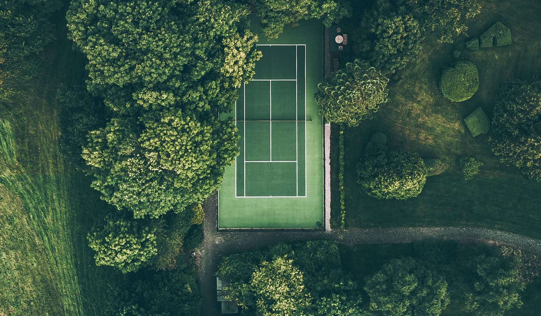 Aerial view of a tennis court surrounded by trees.